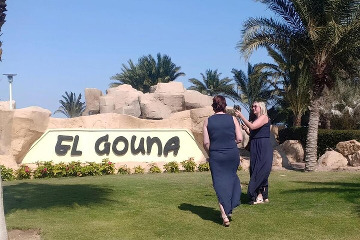 due donne che camminano davanti a un cartello in un resort