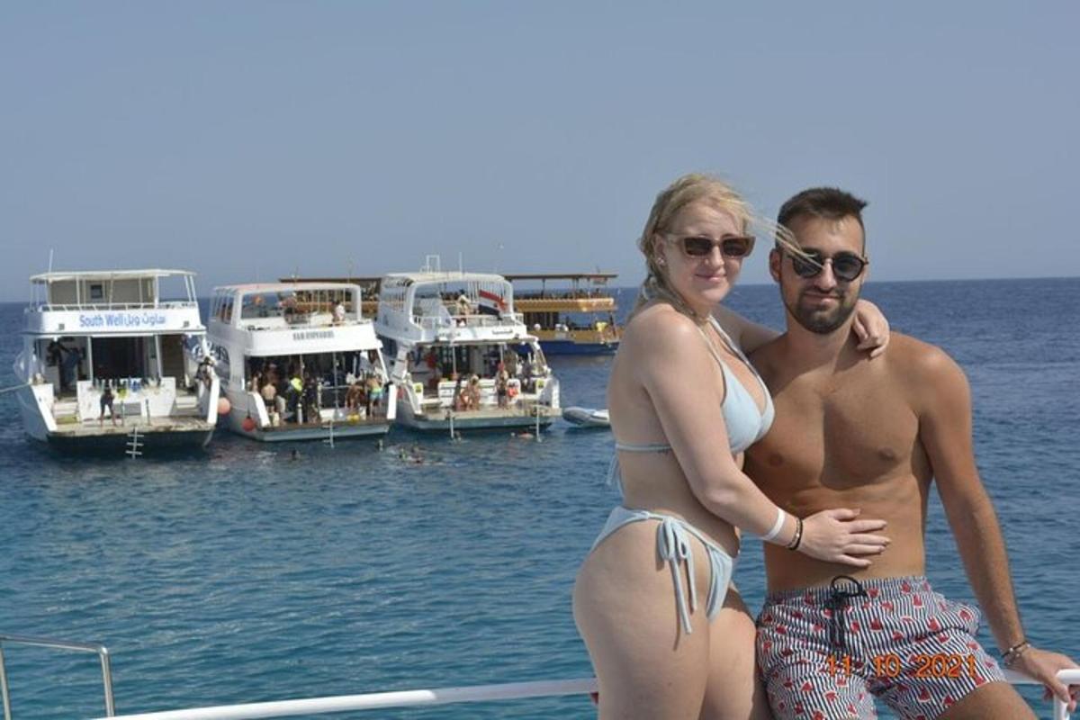 un uomo e una donna in piedi su un molo con delle barche