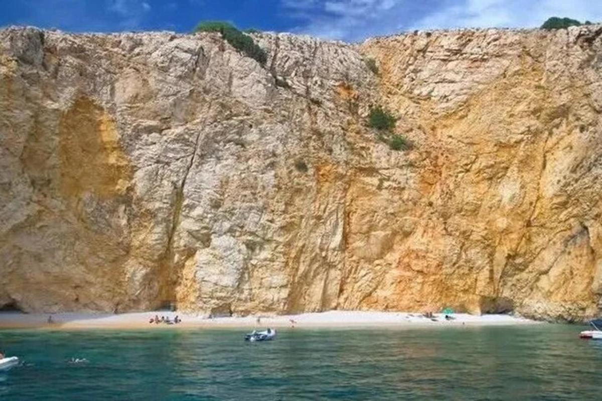 un gruppo di persone su una spiaggia vicino a una scogliera
