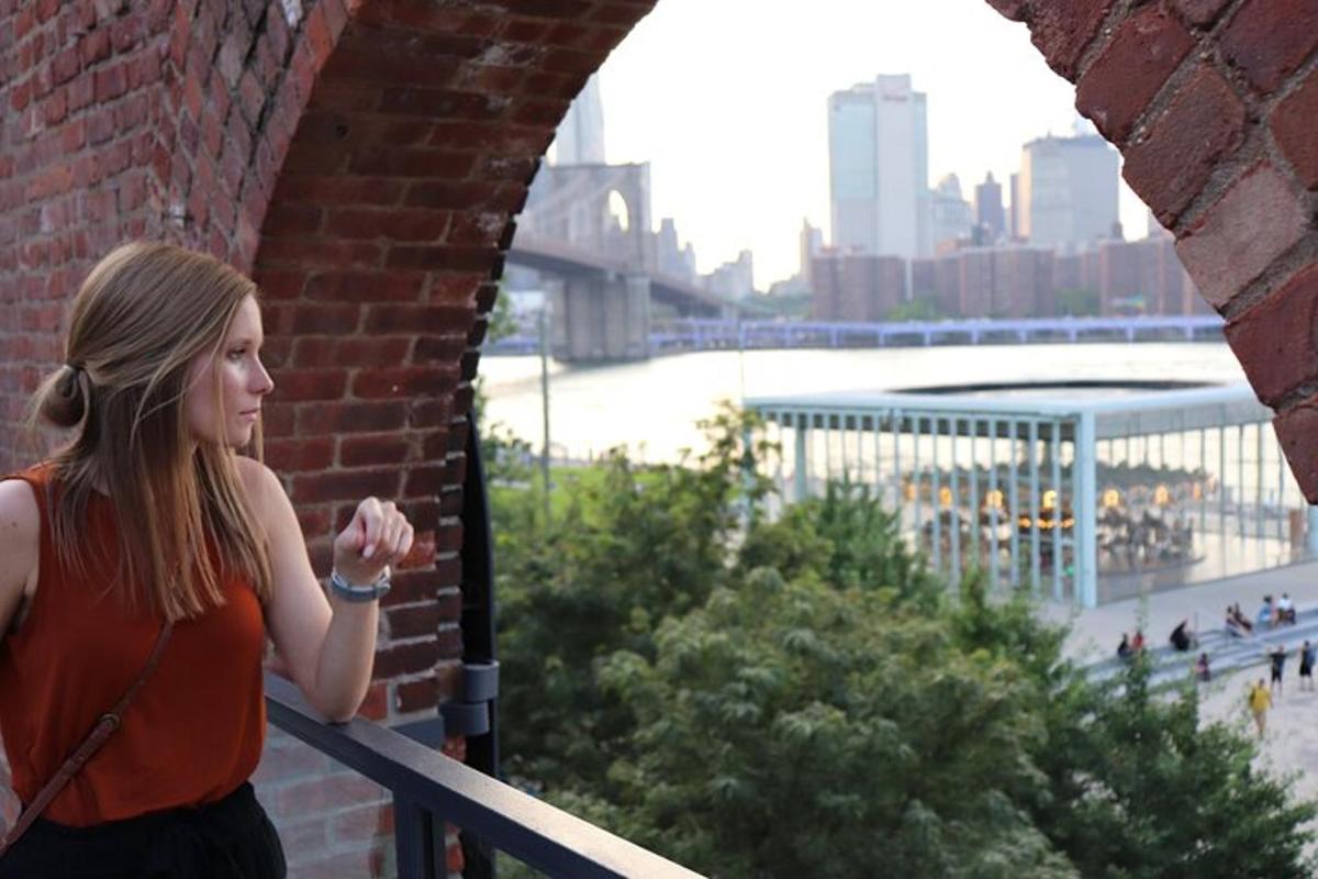 一位女士站在砖墙旁，眺望城市