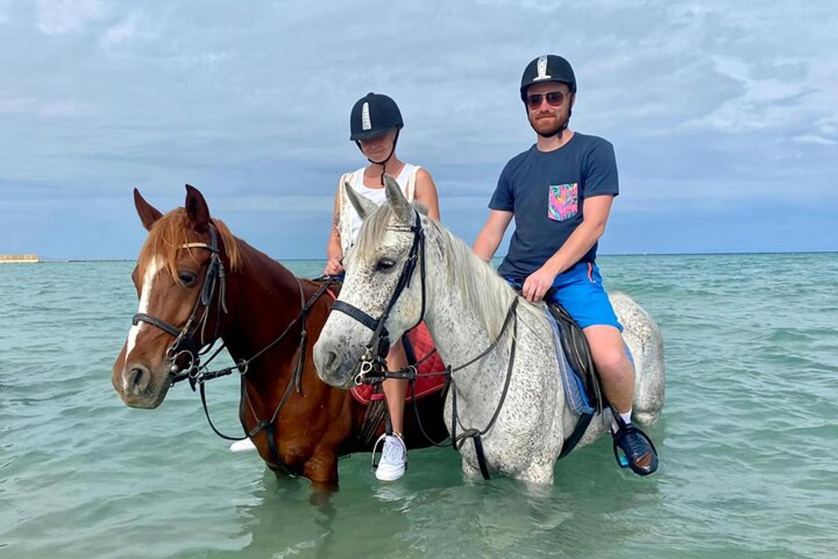 muž a žena jedoucí na koni v oceánu