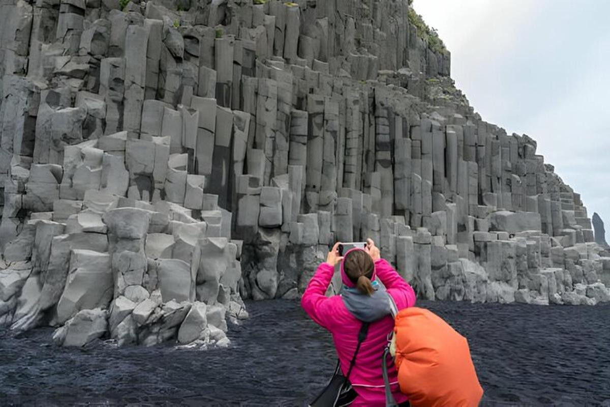 una donna che scatta una foto di una parete rocciosa