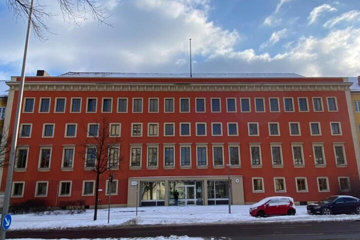 un edificio rosso con auto parcheggiate davanti