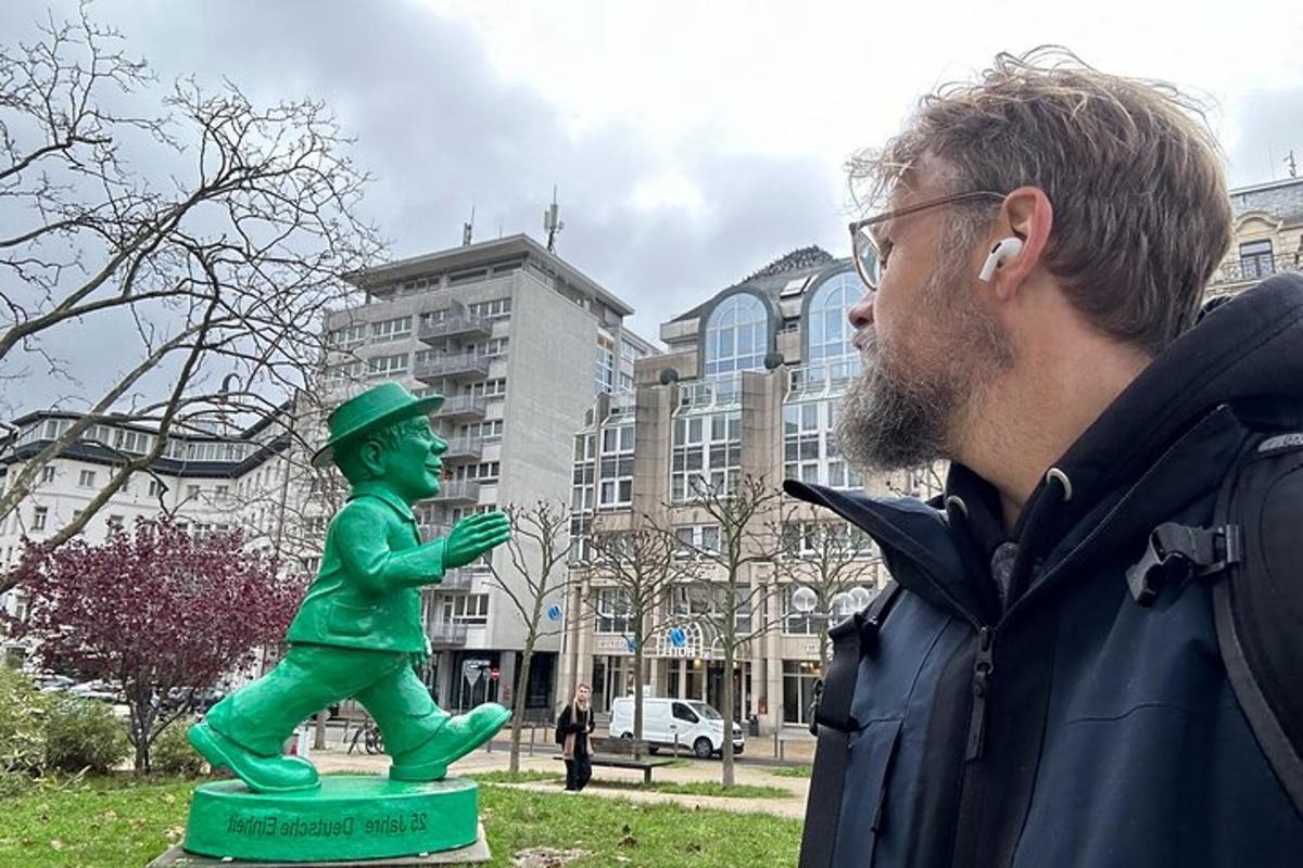 un home dret al costat d'una estàtua verda