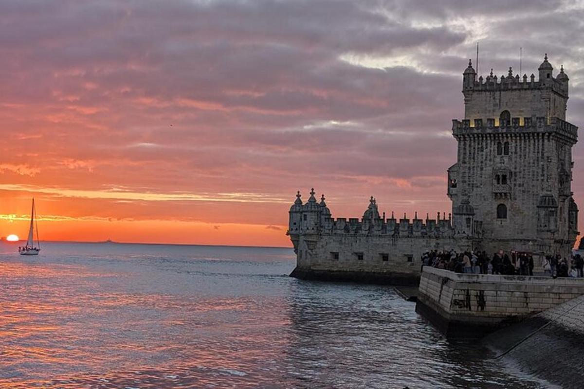 a castle in the water with a sunset in the background