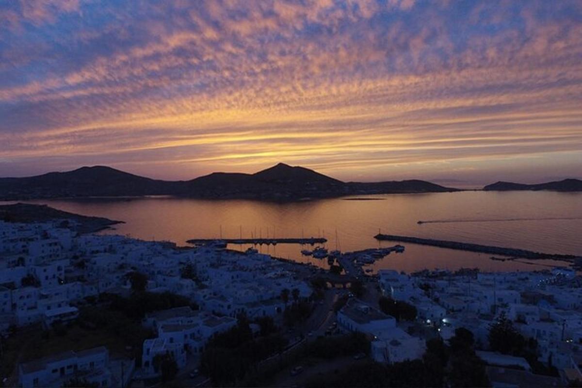 uma vista de uma cidade com um pôr do sol sobre a água