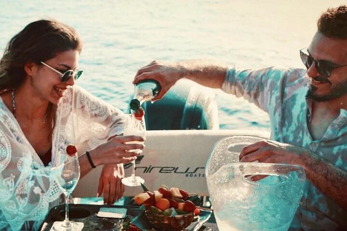 Ένας άντρας και μια γυναίκα πίνουν κρασί σε μια βάρκα