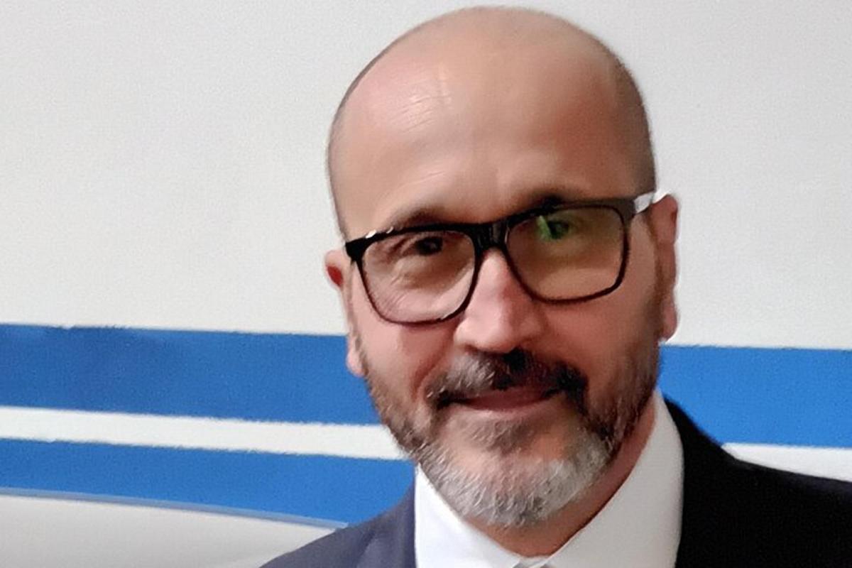 a bald man wearing glasses and a suit