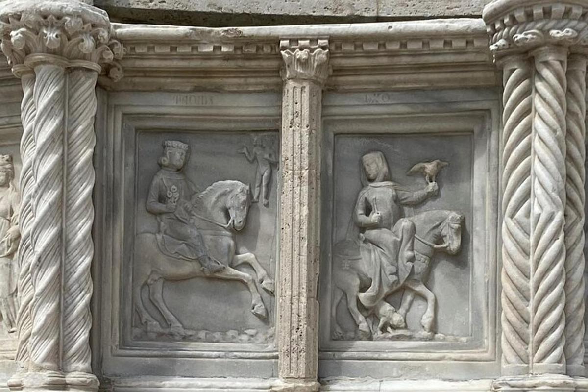 a stone wall with sculptures of people on it