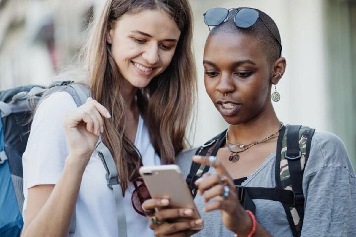 kaks noort naist vaatavad mobiiltelefoni