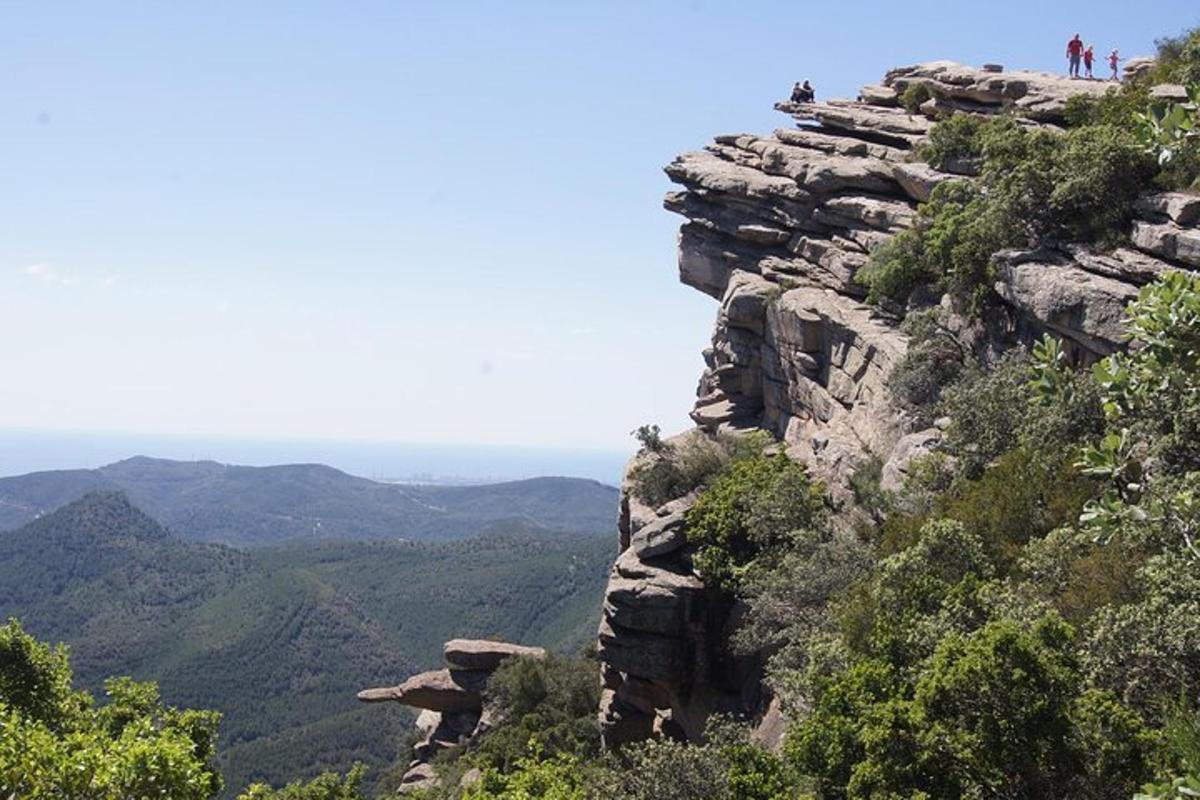two people standing on top of a rocky mountain