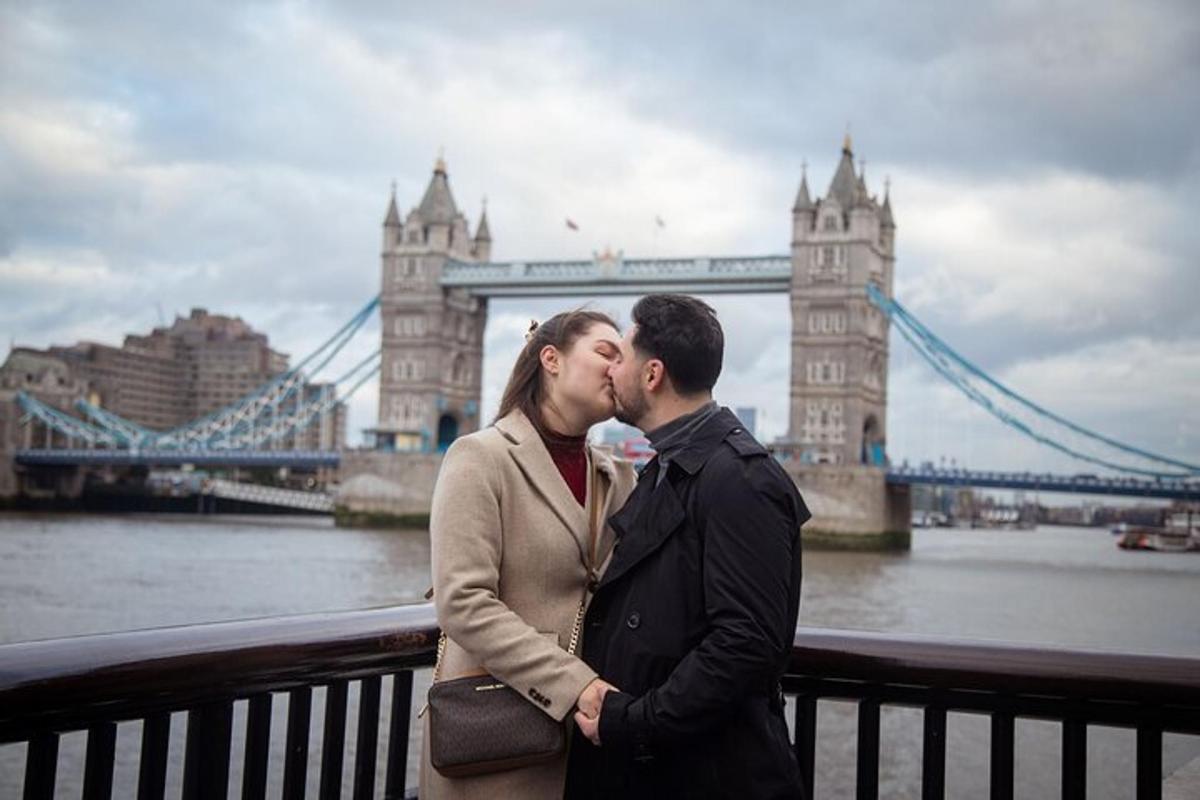 un uomo e una donna che si baciano davanti al Tower Bridge