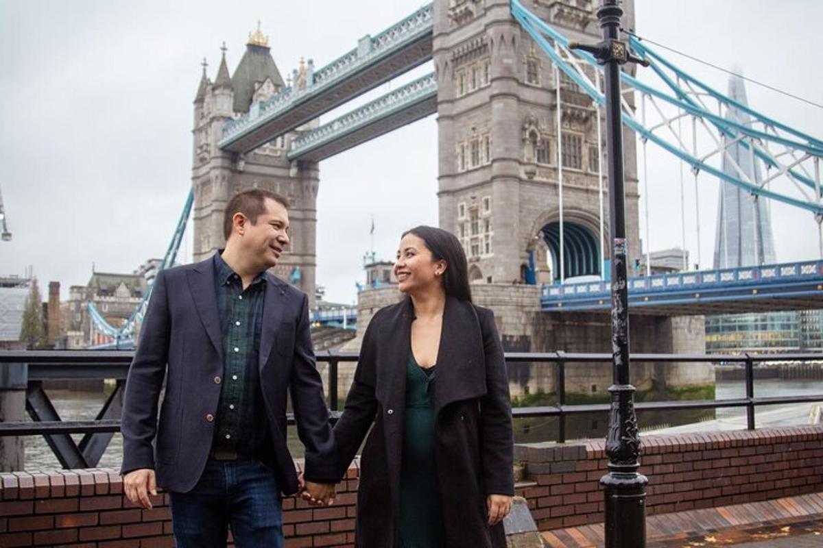 un uomo e una donna che si tengono per mano davanti al Tower Bridge