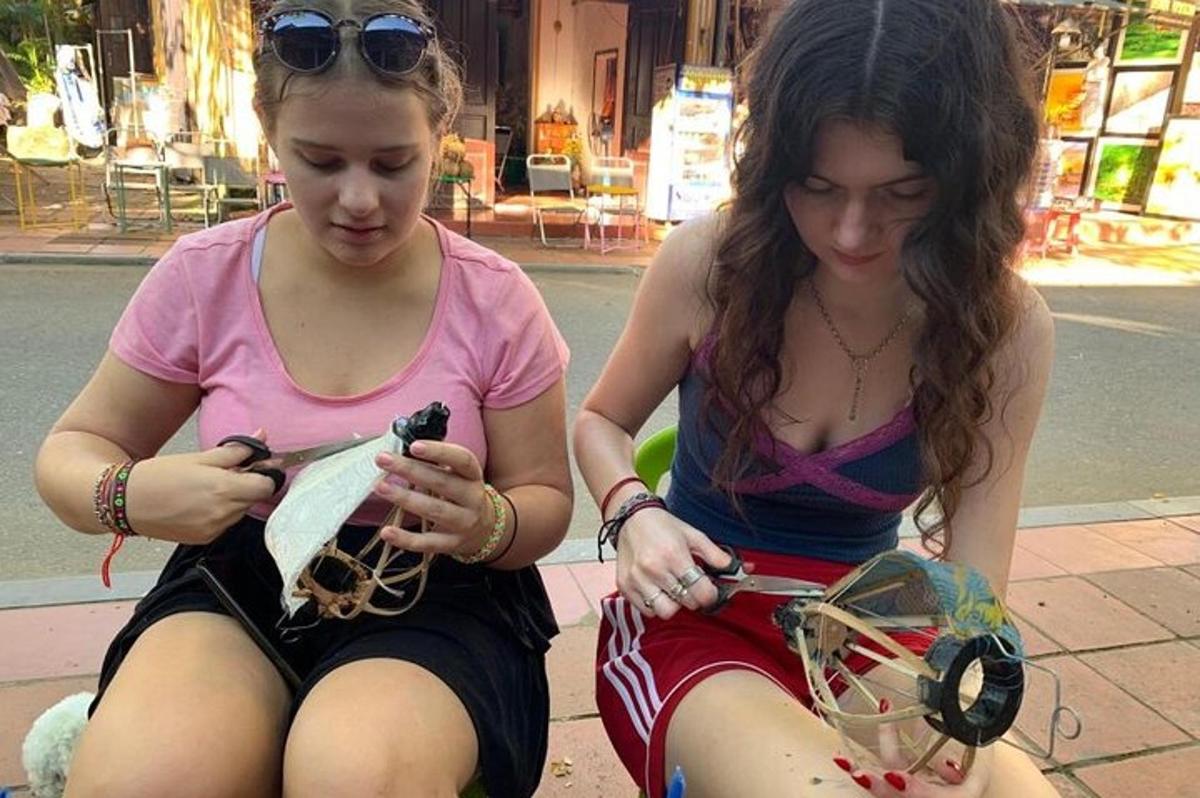 dvě dívky sedící na zemi a dívající se do svých telefonů