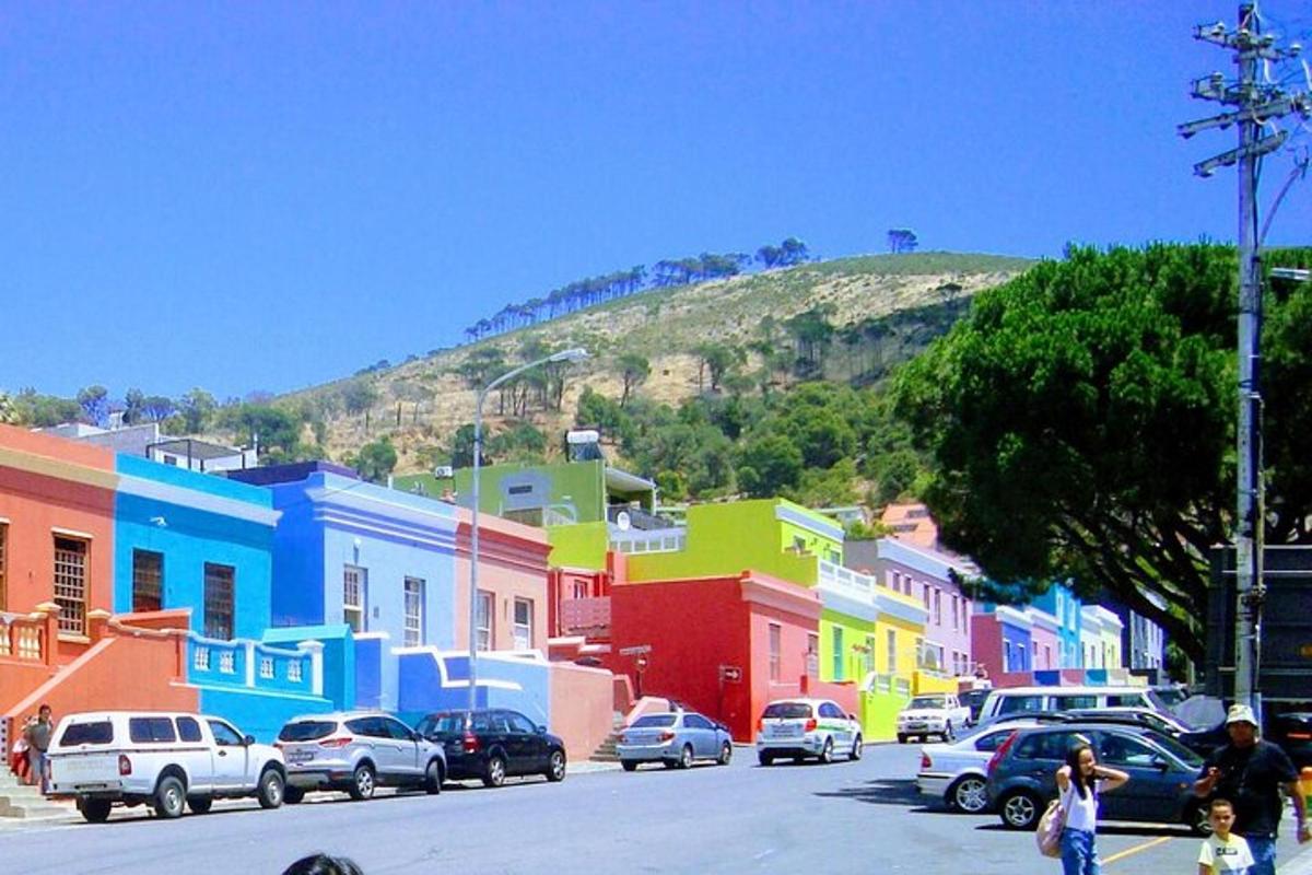 Una calle colorida con coches aparcados en la calle.