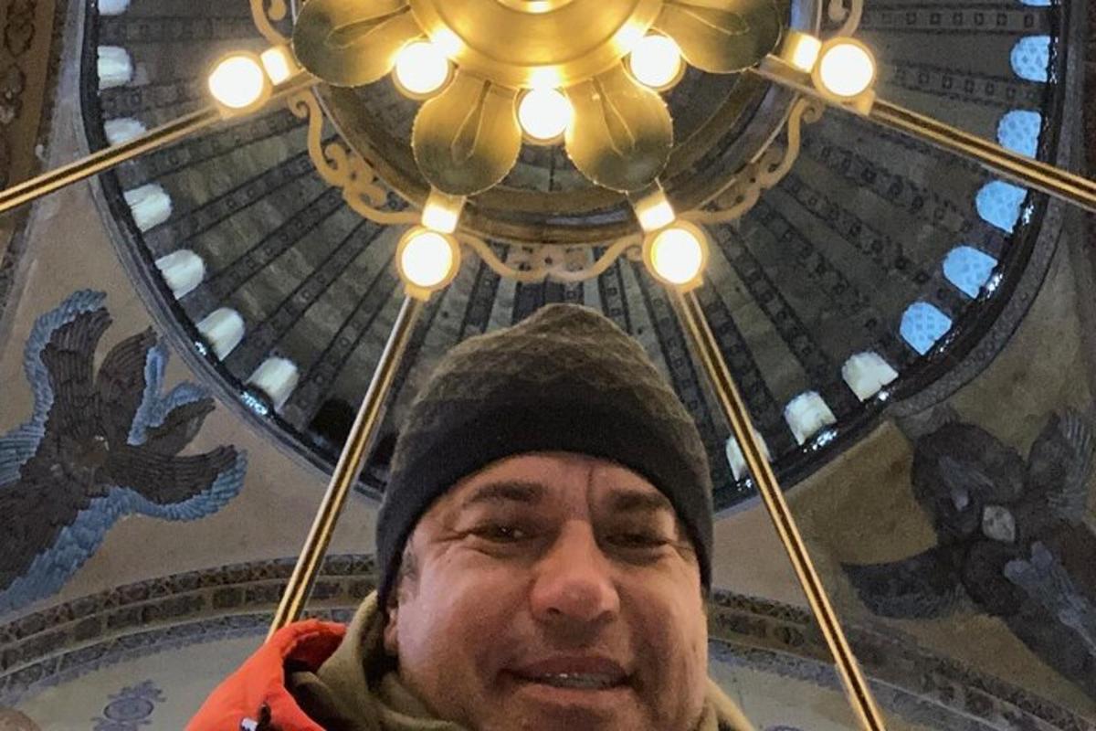 muž s klobúkom pod stropom so svetlami