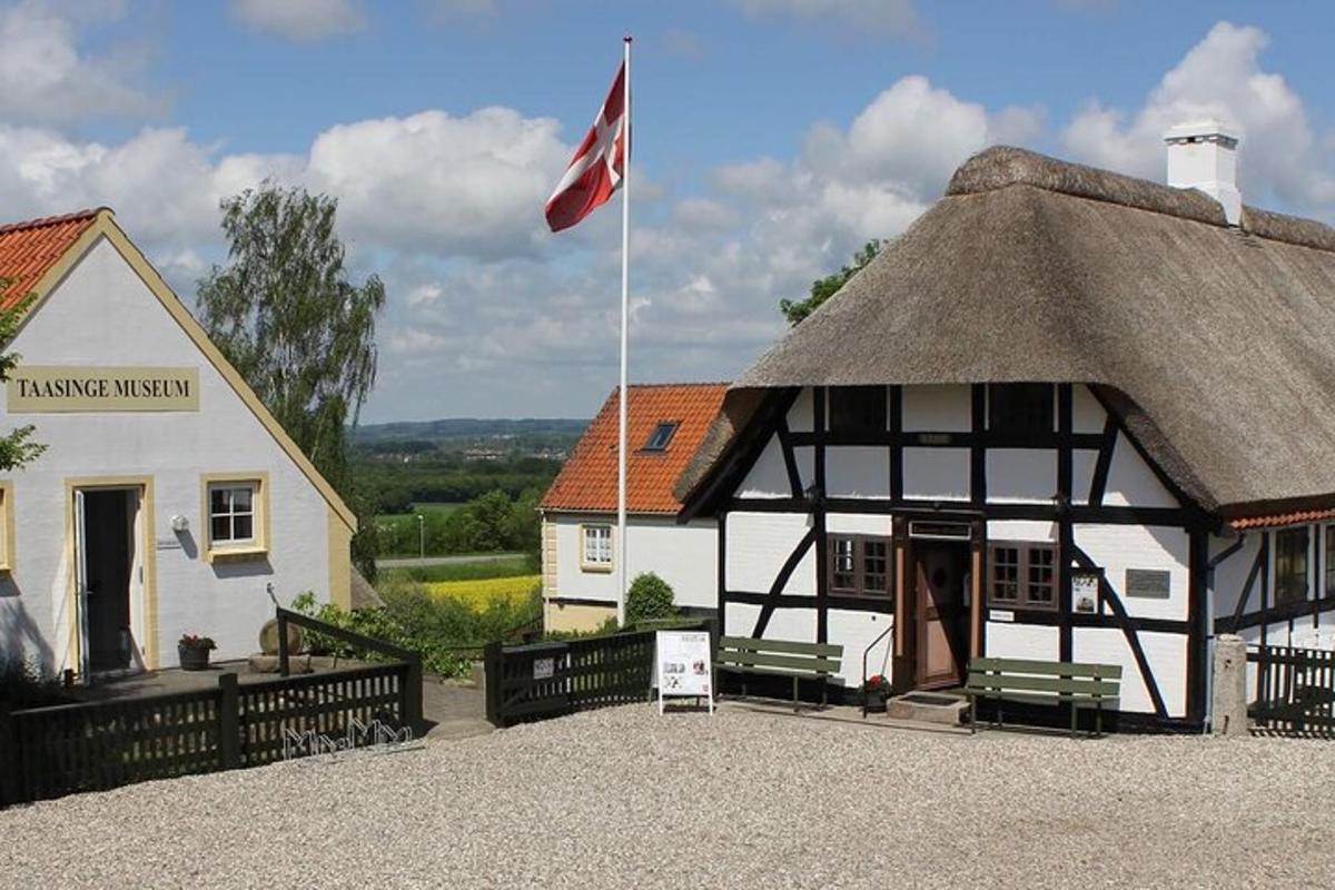 a thatched building with a flag in front of it