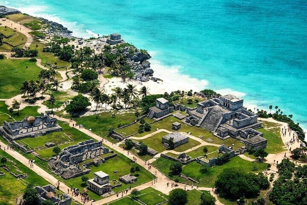 an aerial view of a mansion next to the ocean