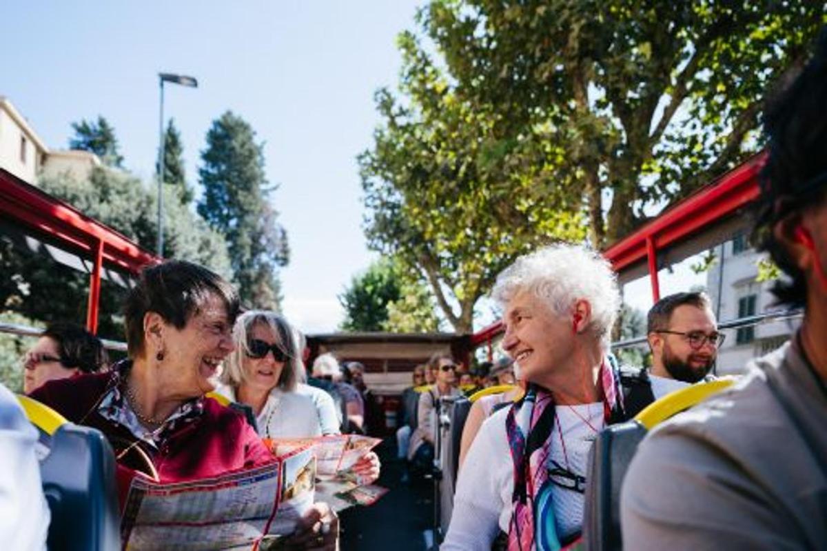 a group of people standing outside of a bus