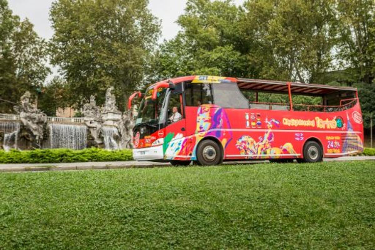 a red bus parked in front of a fountain