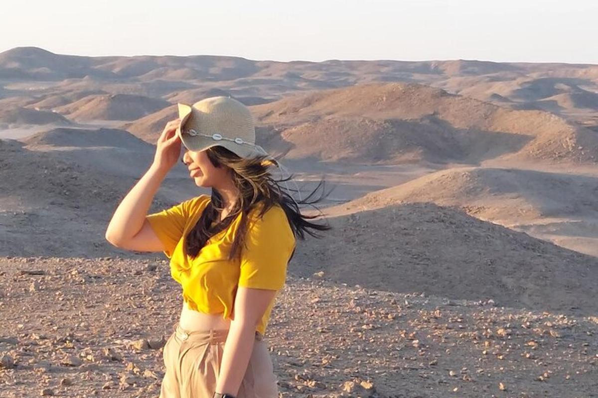 una donna che indossa un cappello in cima a un deserto