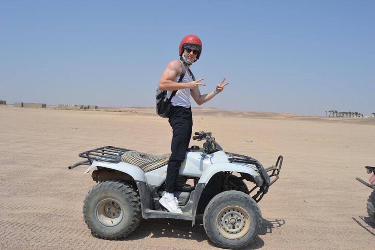 un uomo in piedi su un quad nel deserto