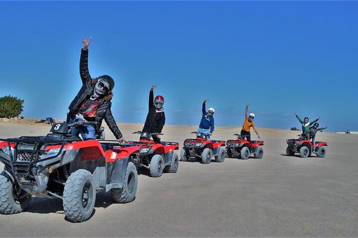 un gruppo di persone in sella a quad sulla spiaggia