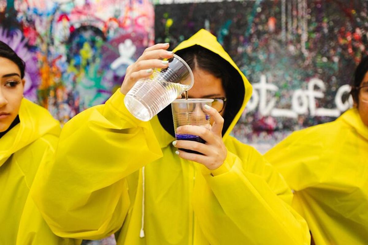 due donne con impermeabili gialli che tengono in mano un drink