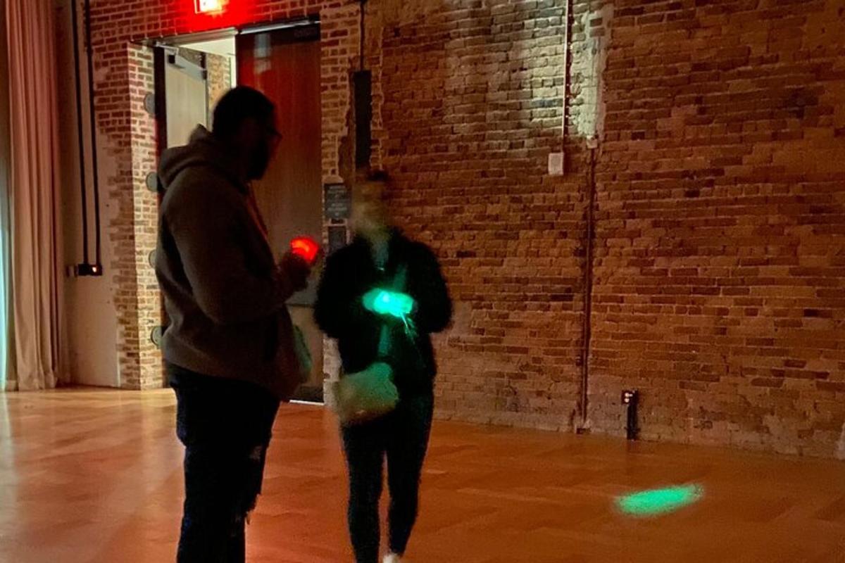 Dos personas caminando en una habitación con luces de neón.
