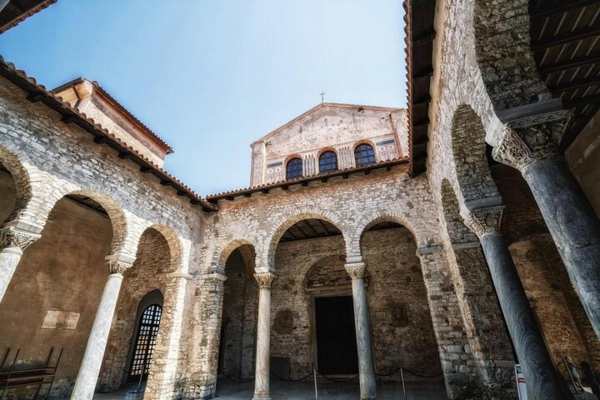 um prédio antigo com arcos e uma igreja ao fundo