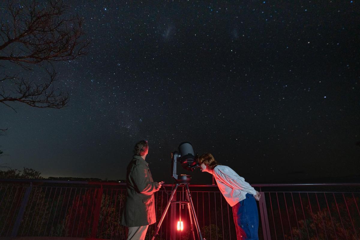 two people looking at the stars in the night sky