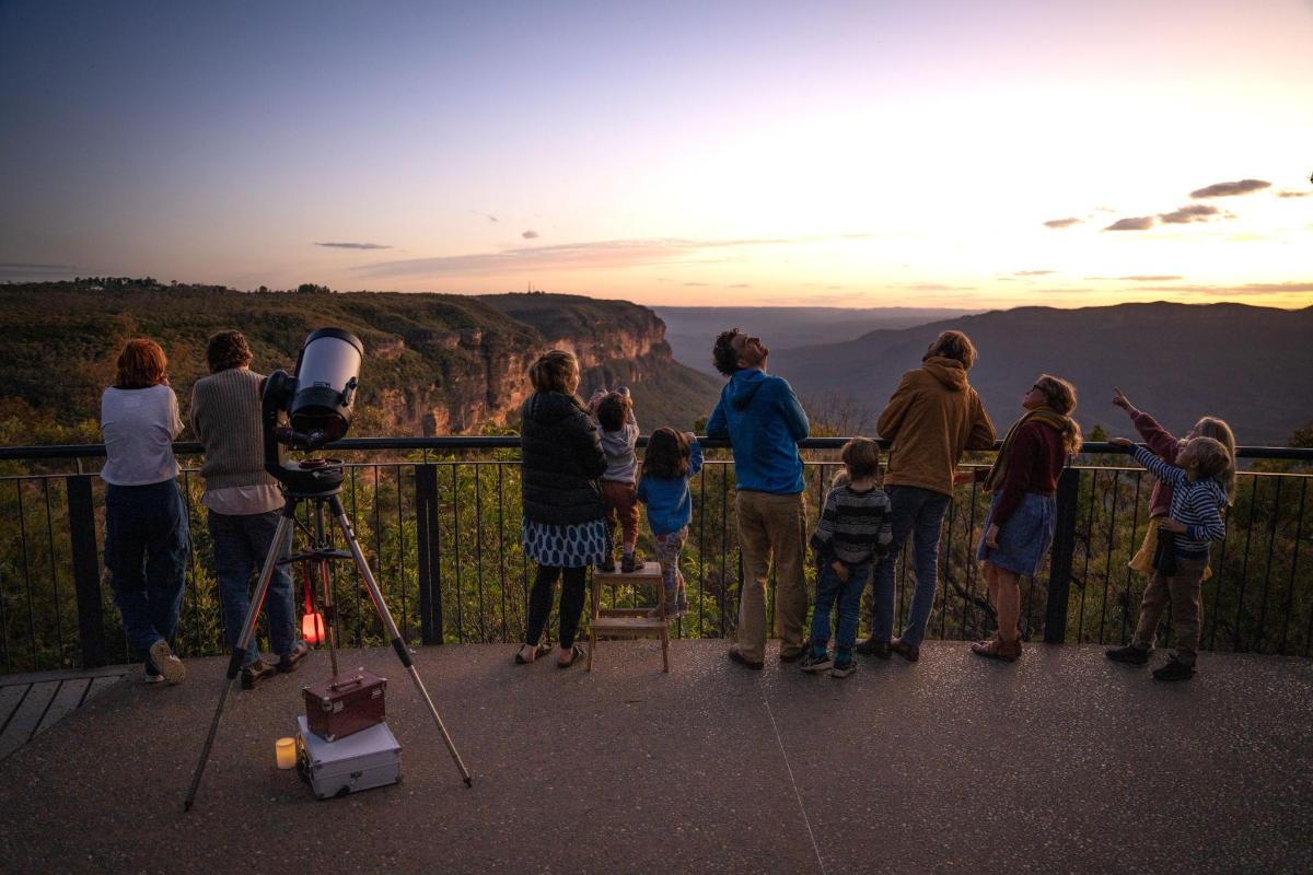 a group of people watching the sunset at the grand canyon