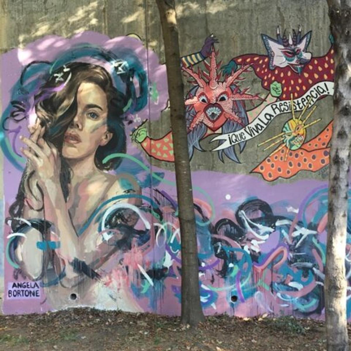 a wall with a painting of a woman on a cell phone