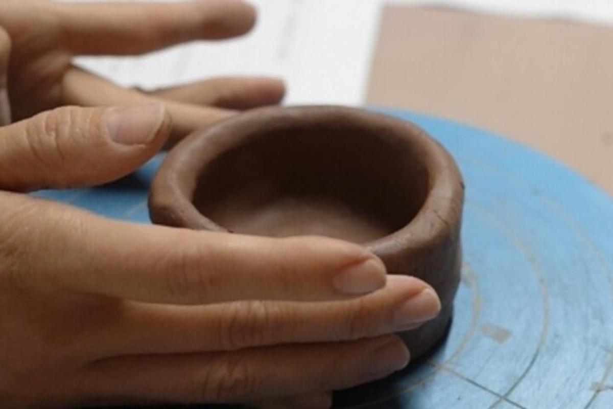 bir kişi masanın üzerinde bir donut tutuyor