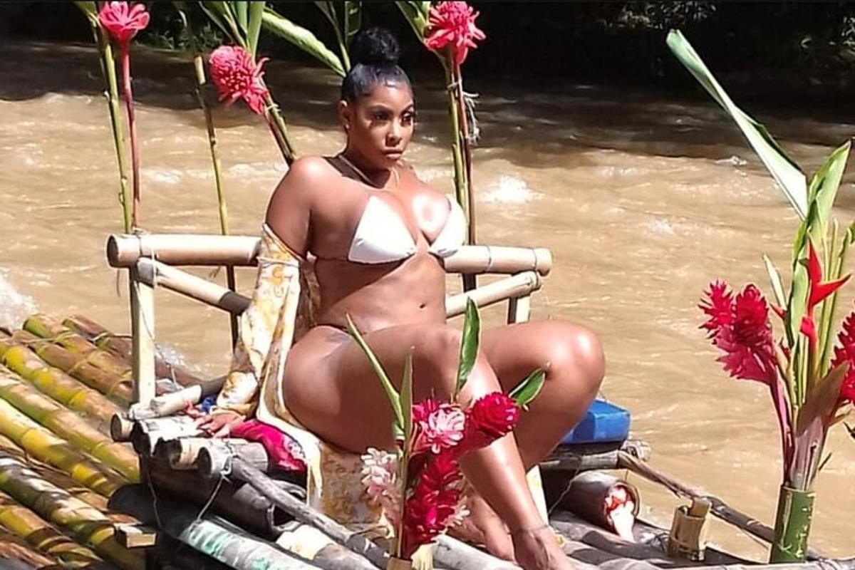 o femeie în bikini stând pe spatele unei bărci