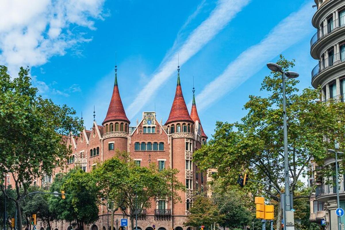 Un gran edificio de ladrillo con torres en una calle de la ciudad.