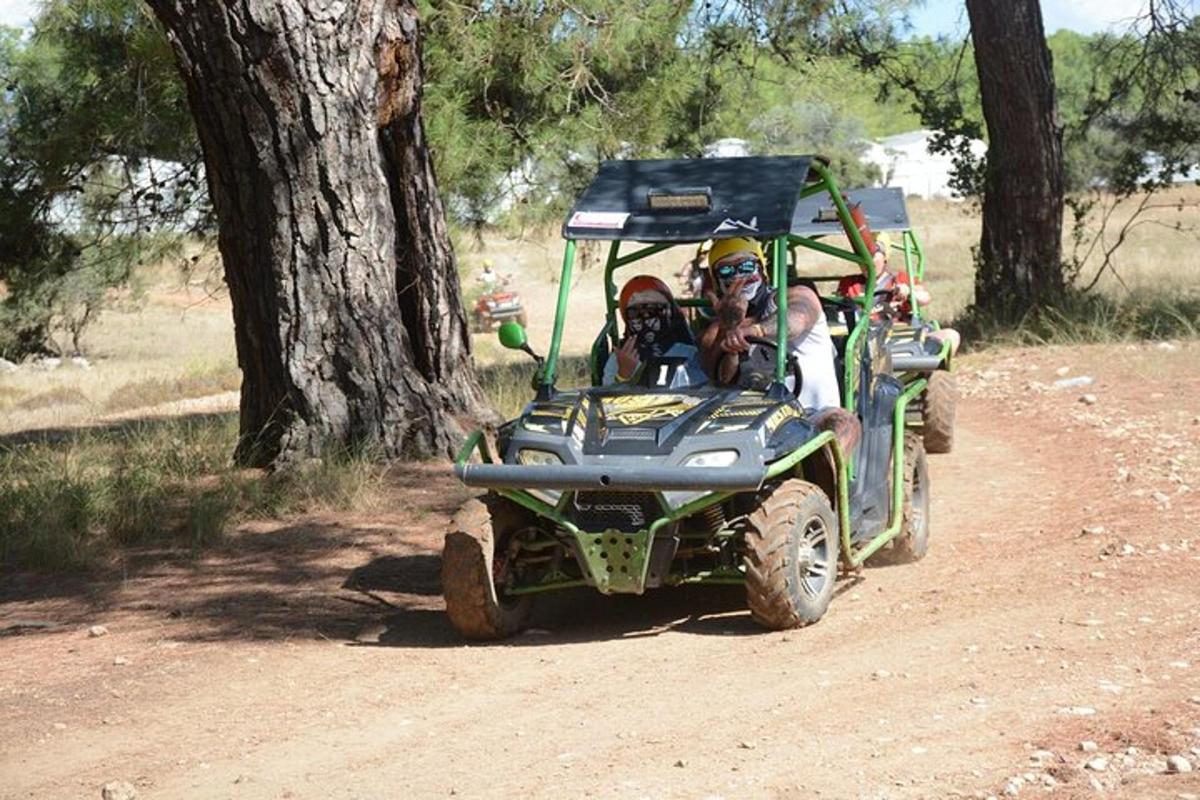 dues persones que viatgen en un quad per una carretera de terra