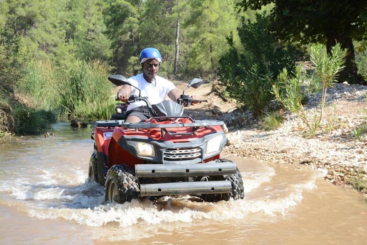 a man riding a four wheeler through a river