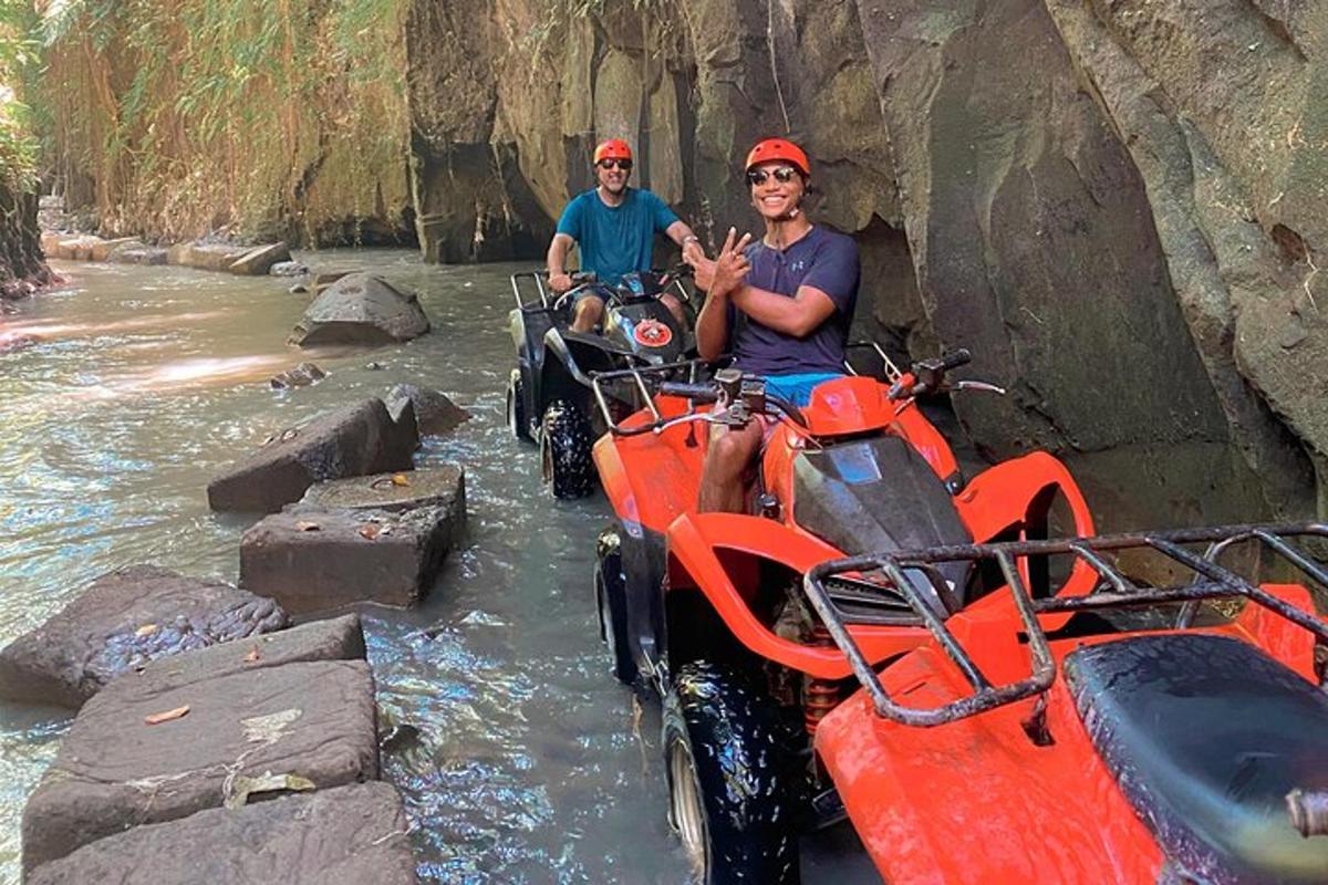 due uomini a bordo di un veicolo a quattro ruote in un fiume