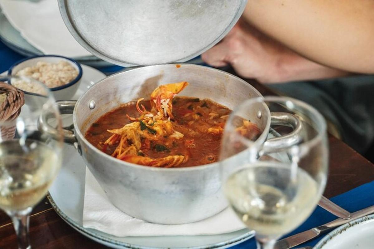 una olla de menjar sobre una taula amb copes de vi