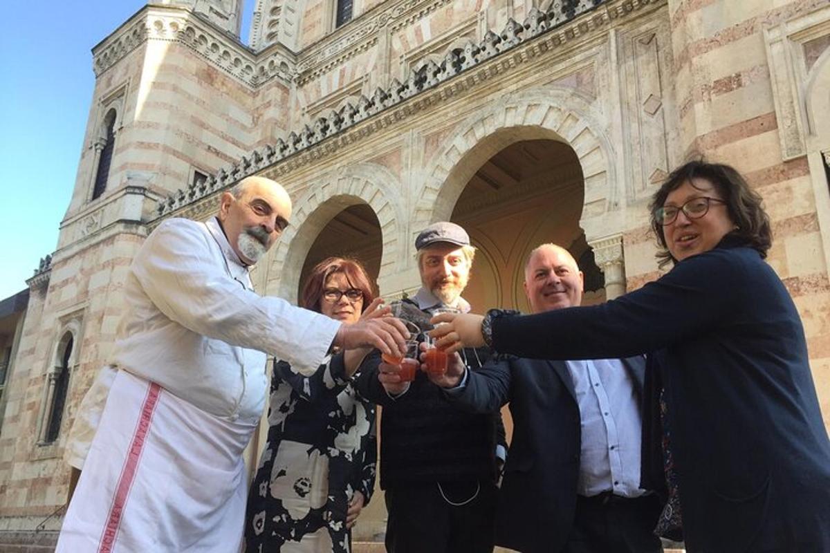 skupina lidí držících se za ruce před budovou