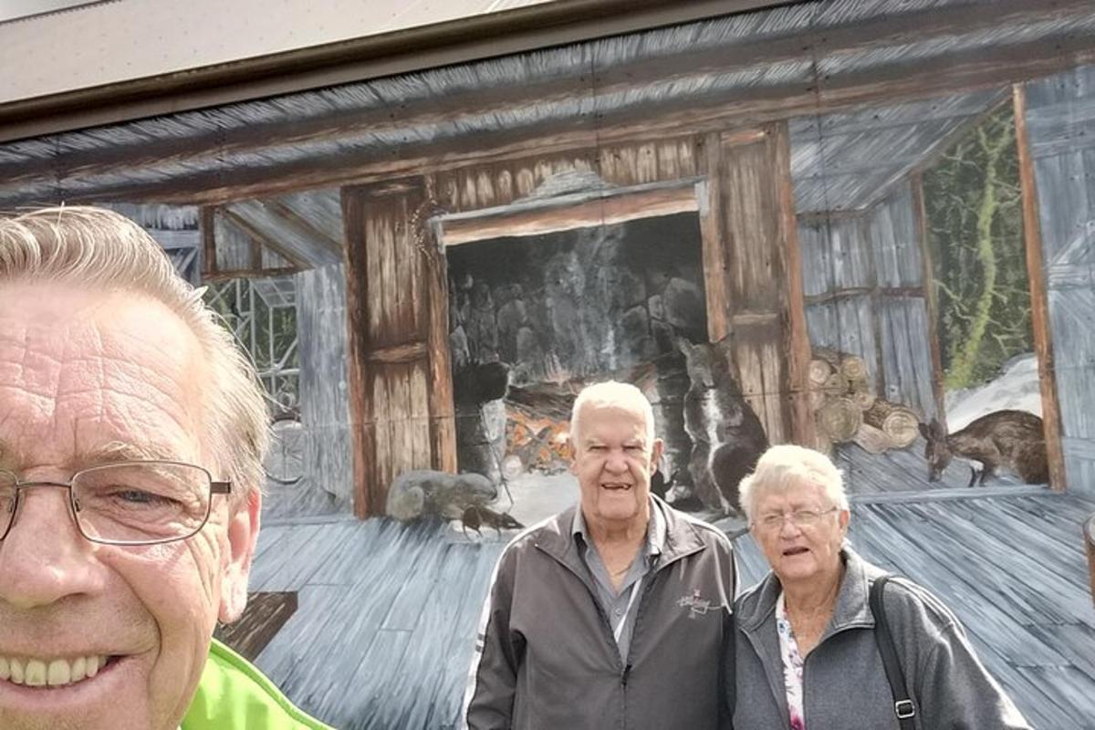 a group of three people standing in front of a painting
