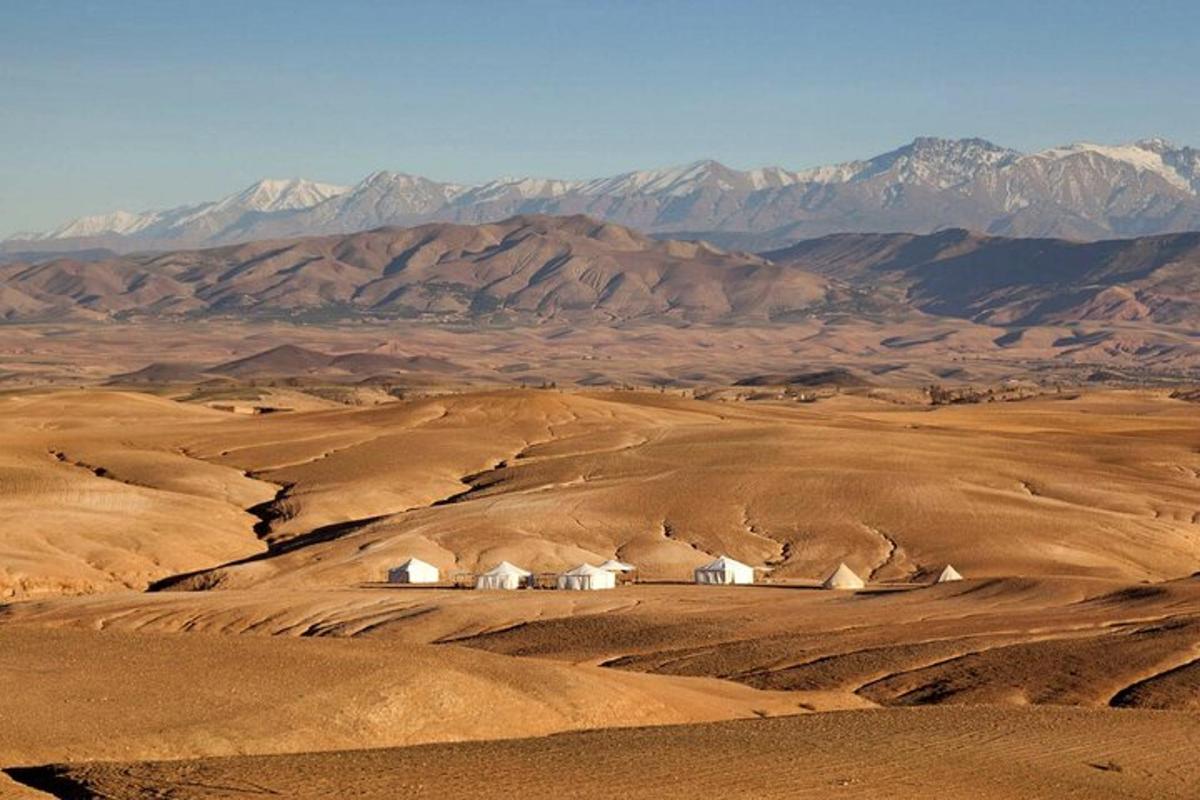 a house in the middle of a desert with mountains
