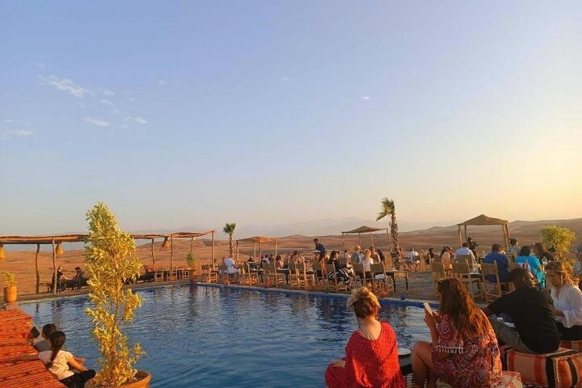 a group of people sitting around a swimming pool