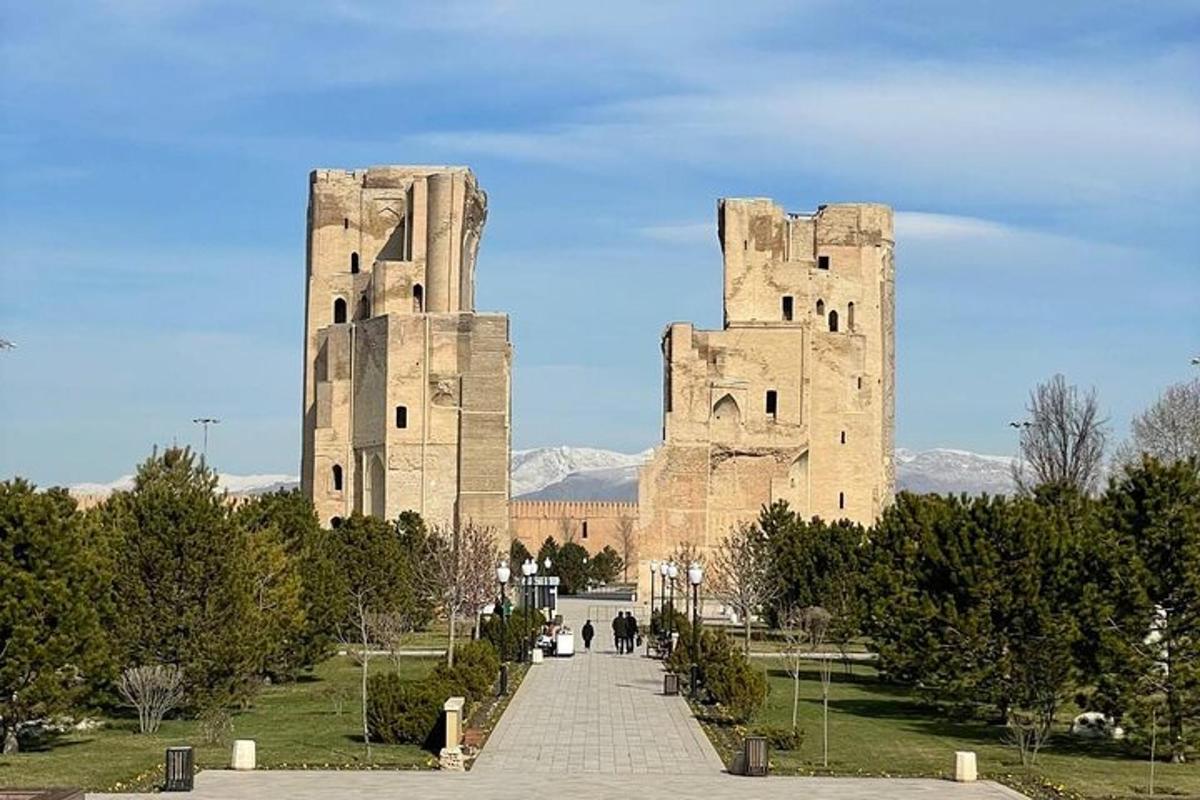 two tall towers in a park with a pathway