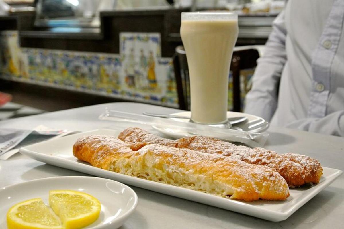 o masă cu două farfurii cu produse de patiserie și un pahar cu lapte