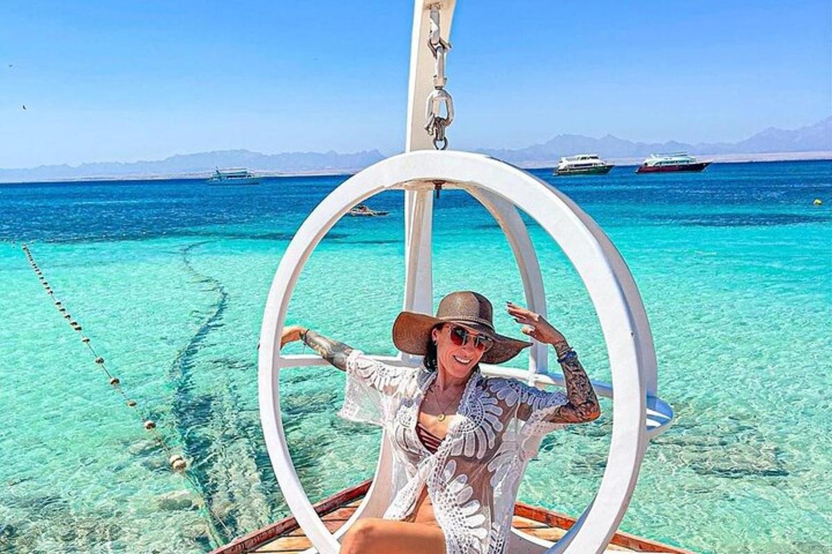 uma mulher está sentada em um arco no oceano