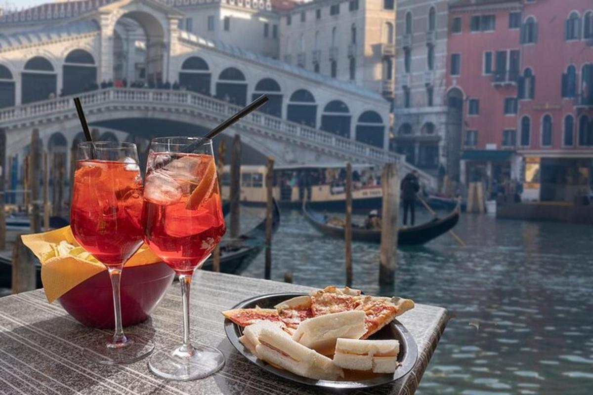 a table with a plate of food and two glasses of wine