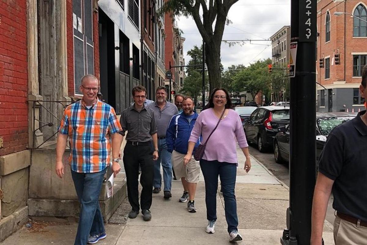 a group of people walking down a sidewalk