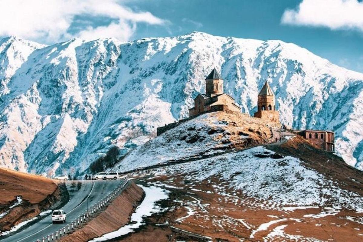 замок на вершині гори із засніженими горами
